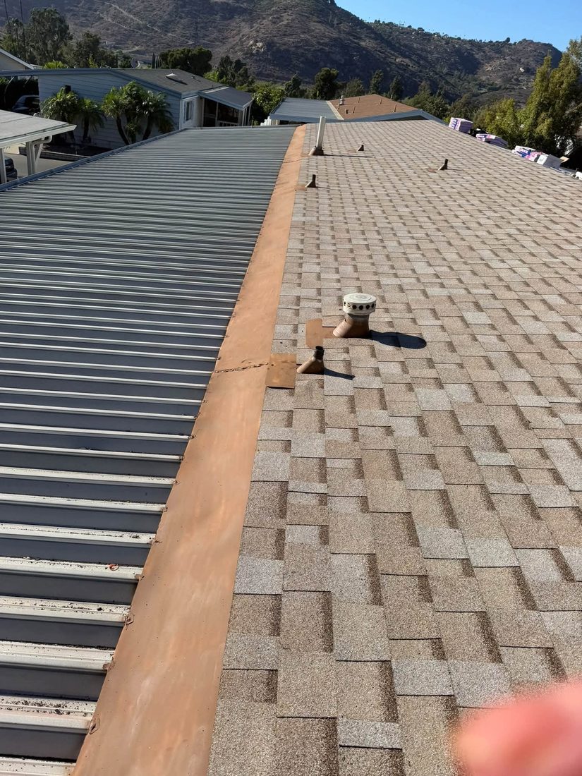 New shingles meeting a metal roof section with flashing